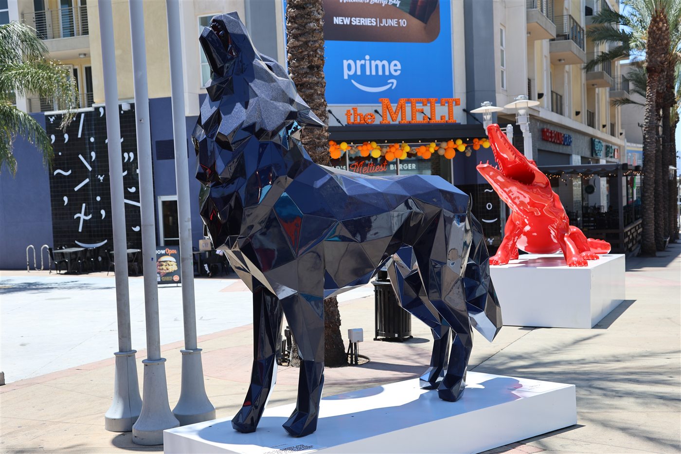 Navy wolf and red wolf sculptures on the AMC Walkway in downtown Burbank